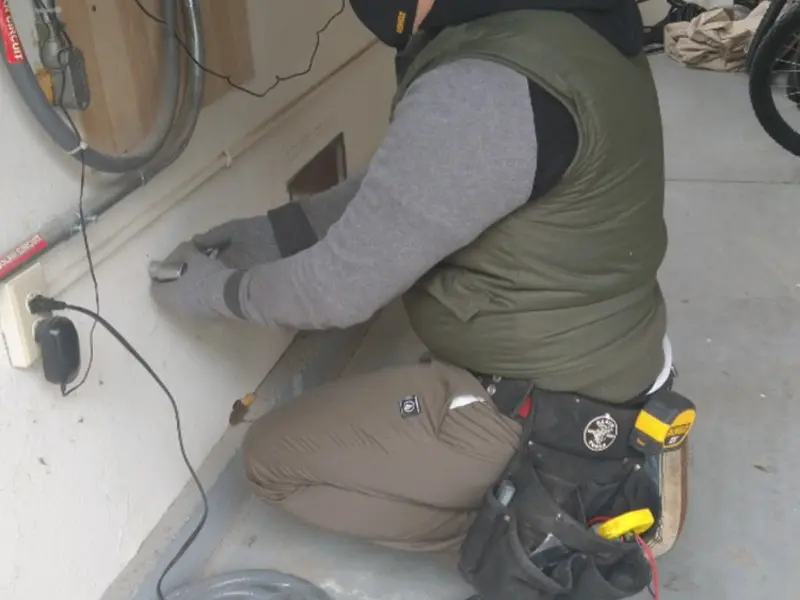 Electrician performing outlet wiring in a White Oak garage